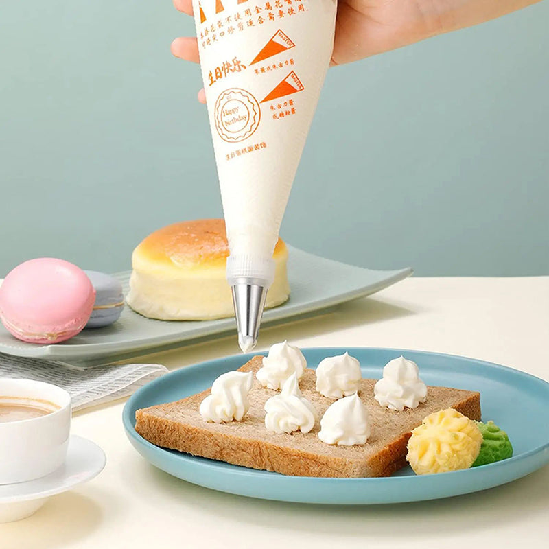 Baker using disposable piping bag to decorate cupcakes with cream frosting icing